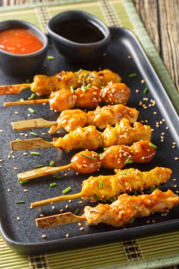 Japon yakitori şişleri masanın üzerinde iki sosla servis edilir. Dikey