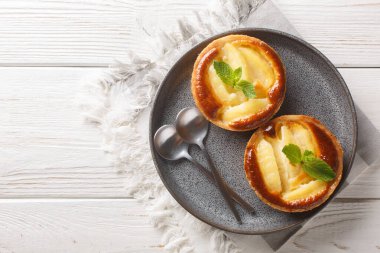 Masadaki nane şekeriyle süslenmiş muhallebi kaplı taze elmalı turtalar. Yukarıdan yatay üst görünüm