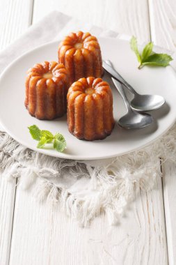 Fransız mutfağı Canele de Bordeaux yakın plan bir tabakta masada. Dikey