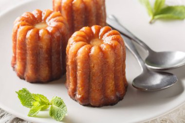 Canele, romlu ve vanilyalı küçük bir Fransız hamur işidir. Yumuşak ve yumuşak bir muhallebi merkezi ve masaya yakın bir tabakta koyu, kalın bir karamelize kabuğu vardır. Yatay