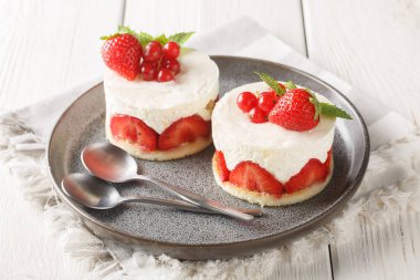 Fraisier cake is a traditional French strawberry cake, consisting of genoise sponge, filled with a silky delicious vanilla mousseline cream closeup on the plate on the table. Horizonta clipart