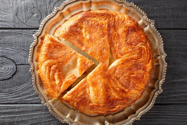 stock image Kouign Amann is a pastry made with a lot of butter from the Brittany region of France closeup on the plate on the table. Horizontal top view from abov