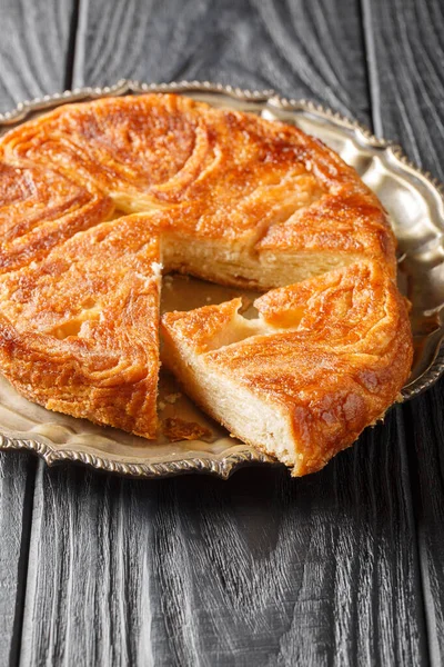 Kouign-amann, masanın üzerindeki tabaktaki kaplamalı hamur kaplamasından yapılmış tatlı bir Breton keki. Dikey