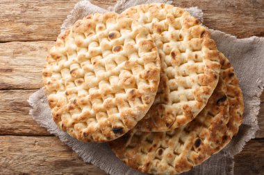 Otantik Yunan pidesi ekmeği ahşap masaya yakın çekim. Yukarıdan yatay üst görünüm