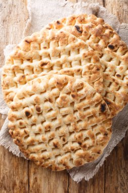 Yunan taze pişmiş düz pide ekmeği ahşap bir masada yakın plan. Yukarıdan dikey üst görünüm