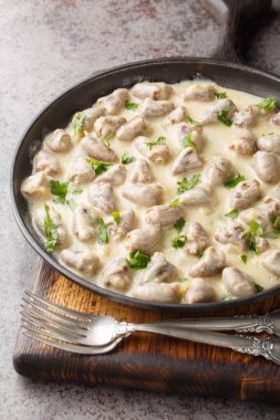 Sarımsaklı krema soslu leziz tavuklar masanın üstünde yakın plan çekimde. Dikey