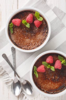 Çikolata kremalı brüle karamelli, naneli ve ahudududulu, masanın üstünde ramekin var. Yukarıdan dikey üst görünüm