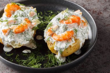 Ekşi krema sosuyla doldurulmuş fırında patates, sarımsak, dereotu ve karidesi masaya yakın bir tabakta. Yatay