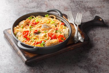 Beyaz deniz balığı, biber, soğan, yeşil bezelye ve domates soslu spagetti güveci. Yatay