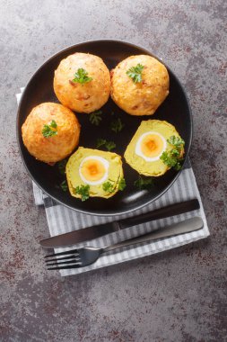 Guyanese Cassava Yumurta Topları masadaki tabağa yakın çekim yapıyor. Yukarıdan dikey üst görünüm