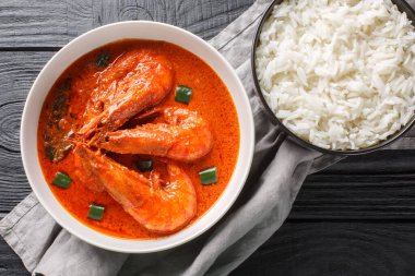 Çingri malai körisi, kaplan ve kral karideslerinden yapılmış karides ve hindistan cevizi sütü olarak da bilinir ve ahşap masa üzerindeki baharatlarla tatlandırılır. Yukarıdan yatay üst görünüm