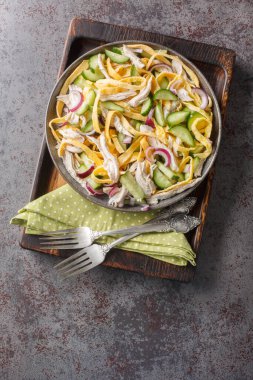 Haşlanmış tavuk salatası, salatalık, kırmızı soğan ve masanın üzerindeki tabakta yakın plan yumurta krepleri. Yukarıdan dikey üst görünüm