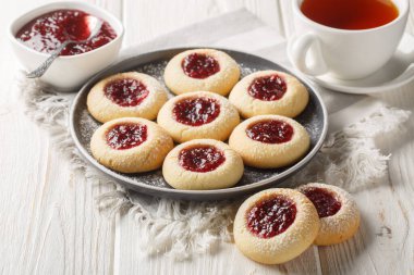 Thumbprint or Hallongrottor Swedish Raspberry Jam Cookies closeup on the plate on the white wooden table. Horizonta clipart