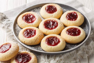 Hallongrottor Swedish Thumbprint Cookies closeup on the plate on the white wooden table. Horizonta clipart