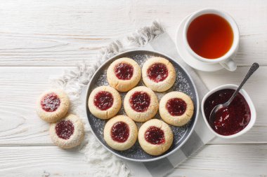 Beyaz ahşap masadaki tabakta İsveç usulü ahududu parmak izi Cookiesclose resmi. Yukarıdan yatay üst görünüm