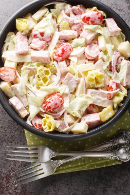 Domatesler, salam, peynir, buzdağı marulu, jambon, soğan ve masaya yakın baharatlı krema soslu biberden oluşan öğütücü salata. Yukarıdan dikey üst görünüm