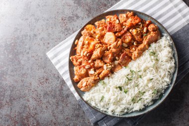 Swedish chicken casserole Flygande Jacob served with rice closeup on the plate on the table. Horizontal top view from abov clipart