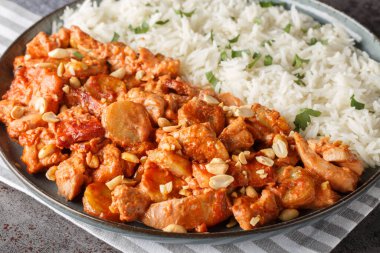 Tavuk, krema, biber sosu, muz, kavrulmuş fıstık ve domuz pastırmasından yapılmış kremalı güveçte Flygande Jakob. Yatay