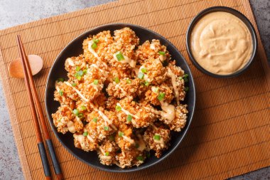 Bang Bang Tavuk leziz bir hamurun içine yerleştirilmiş leziz tavuk parçaları Panko ile çıtır çıtır ve masanın üzerindeki tabağa yakın sosla kaplanmış. Yukarıdan yatay üst görünüm