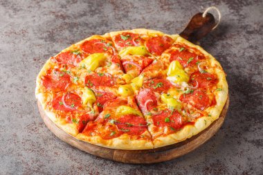 Salamlı dilimlenmiş pizza, Pepperoncini, mozzarella, şifalı otlar ve kırmızı soğanlar masanın üzerinde yakın plan. Yatay