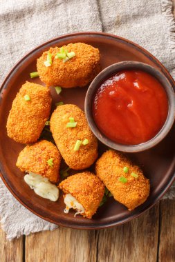 Masanın üstündeki tabağa yakın plan mozzarella suppli al phone ile doldurulmuş kızarmış pirinç topları. Yukarıdan dikey üst görünüm