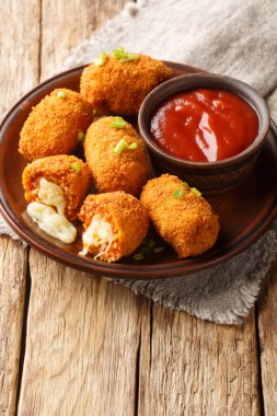 Masanın üstündeki tabağa yakın plan mozzarella suppli al phone ile doldurulmuş kızarmış pirinç topları. Dikey