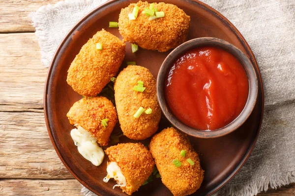 Suppli al telefono Italian snacks consisting of rice with tomato sauce filled with mozzarella, soaked in eggs, coated with bread crumbs and deep-fried closeup. Horizontal top view from abov
