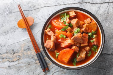 Endonezya yahnisi, domuz eti, domates, soğan, tatlı soya sosu ve Asya baharatları masanın üstünde yakın plan bir kasede. Yukarıdan yatay üst görünüm