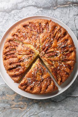 Masada yakın plan bir tabakta tarçın ve inci şekerli ev yapımı elmalı turta. Yukarıdan dikey üst görünüm