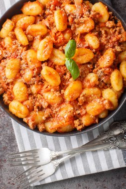 Geleneksel İtalyan mutfağı Patates gnocchi Bolonez soslu ve masada parmesan peynirli yakın çekim. Yukarıdan dikey üst görünüm