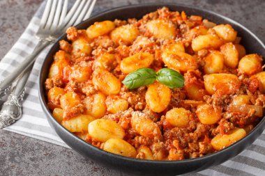 Geleneksel bolonez soslu sıcak patates gnocchi ve masadaki parmesan peyniri kapağı. Yatay