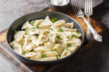 Ev yapımı Polonya mantısı küçük pierogi ya da mantar ve lahana ile doldurulmuş uszka masanın üzerindeki tabakta. Yatay