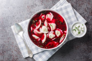 Barszcz z uszkami pancar kökü çorbası, masanın üzerindeki tabakta küçük hamur köfteleri olan borç. Yukarıdan yatay üst görünüm