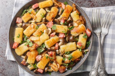 Polonya 'dan gelen patates köfteleri, masaya yakın bir tabakta domuz pastırması, soğan ve mantarla servis edilir. Yukarıdan yatay üst görünüm