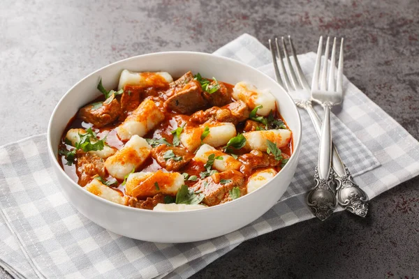 Kopytka Polonya hamur köfteleri ya da patates püresinden yapılmış küçük toynaklar. Masadaki tabakta et sosu ile servis ediliyor. Yatay