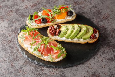 Masanın üzerinde roka, jambon, sebze ve krem peynirli nefis bruschetta. Yatay