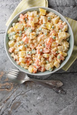 Patates ve ızgara mısır, bezelye, havuç ve elmanın en iyi yaz aromalarını mermer masanın üzerindeki tabakta bir araya getiren Brezilya Gaucho patates salatası. Yukarıdan dikey üst görünüm