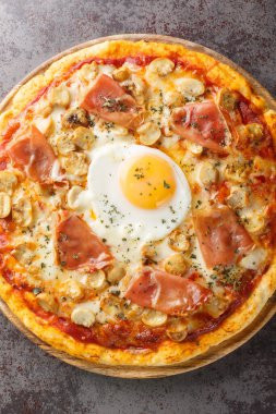 Geleneksel Pizza Bismarck yumurta, mozzarella, domates, mantar ve Prosciutto 'dan yapılmış. Masanın üzerindeki tahta tahtaya yakın çekim. Yukarıdan dikey üst görünüm