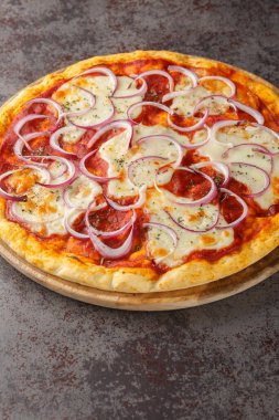 Pugliese Pizzası üzerine domates sosu, mozzarella ve masanın üzerindeki ahşap tahtada kırmızı soğan yakın plan pizza. Dikey