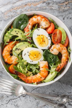 Kaplanlı karides, avokado, roka, ıspanak, domates ve susam tohumlu diyet salatası. Yukarıdan dikey üst görünüm