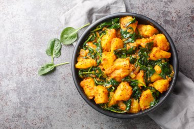 Saag aloo, baharatlarla kızartılmış patatesler ve masadaki ıspanak yakın plan ıspanak içeren klasik Hint tarzı bir meze. Yukarıdan yatay üst görünüm