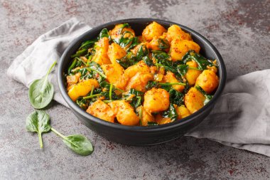 Saag aloo, baharatlarla kızartılmış patatesler ve masadaki ıspanak yakın plan ıspanak içeren klasik Hint tarzı bir meze. Yatay