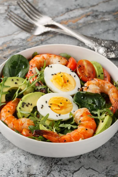 Kaplanlı karides, avokado, roka, ıspanak, domates ve susam tohumlu diyet salatası. Dikey
