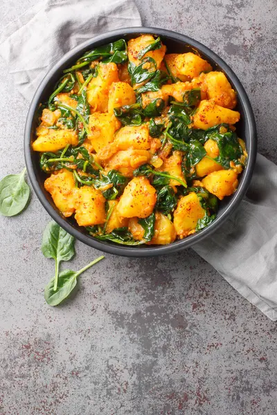 Aloo Palak sabzi ıspanaklı patates körisi masada yakın planda servis edilir. Yukarıdan dikey üst görünüm