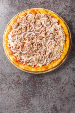 Pizza Tuna, domates sosu, konserve ton balığı, mozzarella peyniri ve ahşap bir tahtada yakın plan kırmızı soğan karışımı. Yukarıdan dikey üst görünüm