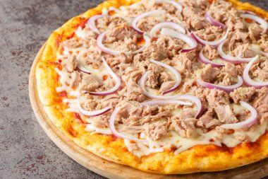 Konserve ton balıklı pizza ve kırmızı soğanlı cipolla. Masanın üzerindeki tahtanın üstünde. Yatay