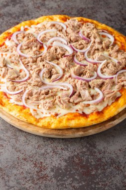Pizza Tuna, domates sosu, konserve ton balığı, mozzarella peyniri ve ahşap bir tahtada yakın plan kırmızı soğan karışımı. Dikey