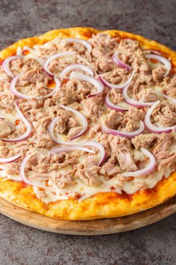 Domates soslu pizza tono e cipolla, mozzarella, ton balığı, ve masadaki ahşap tahtaya yakın soğan dilimleri. Dikey