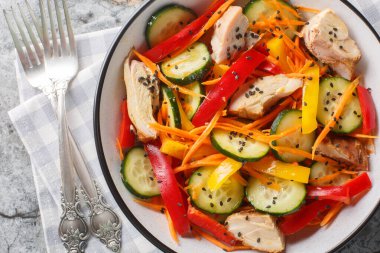 Taze sebzeli ve susam tohumlu diyet tavuk salatası masanın üstünde. Yukarıdan yatay üst görünüm