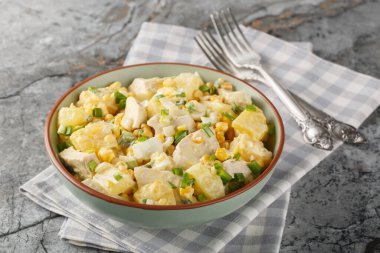 Masadaki tabakta mısır, peynir, yumurta ve soğanlı ev yapımı tavuk göğsü ananas salatası. Yatay